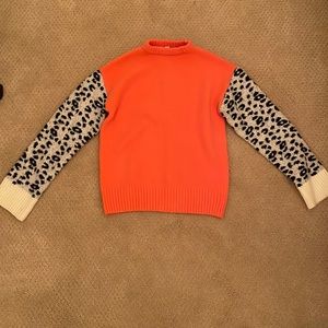 coral sweater with black and white cheetah print sleeves